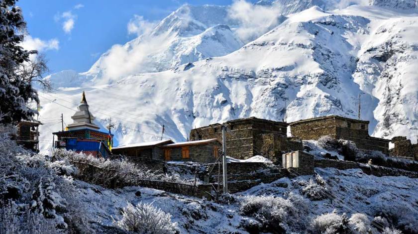 Stone houses on the lap of snow capped peaks 